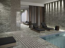 Luksusowe spa z basenem, ciemnymi leżakami, kanapą, drewnianym przepierzeniem i płytkami imitującymi kamień z kolekcji Sutton