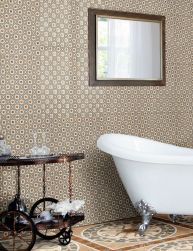 Łazienka wyłożona dekoracyjnymi płytkami Rialto z białą wanną, stolikiem retro oraz lustrem w drewnianej ramie