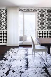 Elegancki pokój ze ścianą wyłożoną biało-czarną mozaiką Mini Hexagon B&W Lace ze stołem i krzesłem