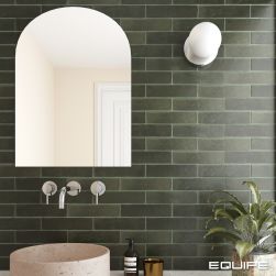 Zbliżenie na ścianę w łazience wyłożoną zielonymi cegiełkami z kolekcji Argile, z okrągłą umywalką nablatową i baterią podtynkową, lustrem, kwiatem i kulistym kinkietem