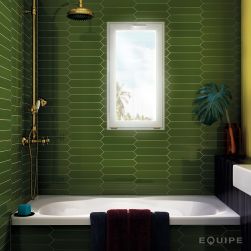 Mała łazienka wyłożona zielonymi płytkami w kształcie strzały z kolekcji Arrow Green Kelp, z zabudowaną wanną, złotym zestawem prysznicowym i małym oknem