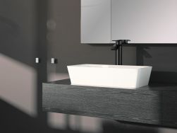 Ciemna łazienka z ciemną, drewnianą półką wiszącą, a na niej białą umywalką prostokątną Besco Assos oraz z czarną baterią stojącą i lustrem