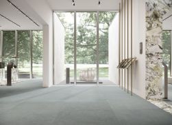Przestronne pomieszczenie publiczne z płytkami imitującymi beton Balance Azure na podłodze