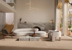 Salon z beżowymi płytkami imitującymi beton Balance Tan na podłodze, z kanapą, dwoma fotelami, krzesłem, marmurowym stolikiem i kominkiem