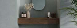 Ściana w łazience wyłożona płytkami imitującymi beton Balance Azure, z półką kosmetykami i lustrem