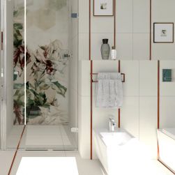 Fragment łazienki wyłożonej białymi płytkami z czerwonymi paskami, kabiną prysznicową z kwiatowym dekorem, białym bidetem z baterią Barcelona i obrazkami na ścianie