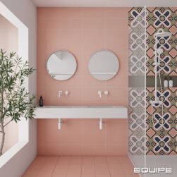 Pastelowa łazienka wyłożona różowymi bazowymi i patchworkowymi płytkami z kolekcji Bauhome z kabiną prysznicową z białym zestawem prysznicowym, wiszącą półką białą z dwiema wpuszczanymi umywalkami, bateriami podtynkowymi i dwoma okrągłymi lustrami