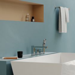 Niebieska ściana z półką i zamontowaną na niej baterią nawannową w chromie z kolekcji Omnires Slide z białą wanną prostokątną, ręcznikiem wiszącym na ścianie i pomarańczową półką wewnętrzną z kosmetykami