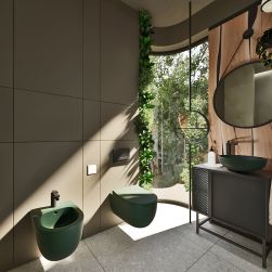 Łazienka z półokrągłą ścianą, zielonym bidetem wiszącym Molis Green oraz pasującą miską WC, szarą szafką z umywalką nablatową zieloną i okrągłym lustrem
