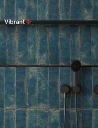 Ściana prysznica wyłożona niebieskimi cegiełkami z kolekcji Vibrant z ciemną armaturą