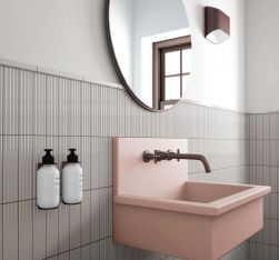 Łazienka z szarymi cegiełkami w połysku i reliefami Costa Nova Onda Grey Gloss na ścianie, różową umywalką i okrągłym lustrem