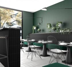 Restauracja ze ścianą wyłożoną zielonymi cegiełkami matowymi Costa Nova Laurel Green Matt z czarnymi stolikami, krzesłami i zieloną kanapą