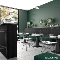 Restauracja z czarnymi cegiełkami matowymi z reliefami Costa Nova Black Matt na barze i ścianie, z czarnymi stolikami, krzesłami i zieloną kanapą