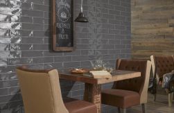 Klimatyczna restauracja z kwadratowymi stolikami drewnianymi i krzesłami z brązowymi obiciami, czarnymi lampami wiszącymi, drewnianą podłogą i ciemnymi cegiełkami na ścianie z kolekcji Poitiers