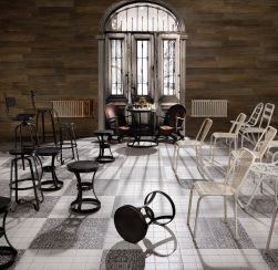 Pomieszczenie z dużym oknem, czarnymi i białymi krzesełkami, okrągłym stolikiem z szachami i płytkami podłogowymi FS Faenza-N 33x33