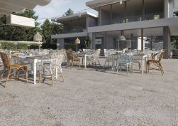 Taras ze stolikami, krzesłami, widokiem na biały dom i płytkami z kolekcji FS Venecia