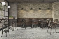 Restauracja z brązową kanapą, krzesłami, stołkami, kinkietami i płytkami z kolekcji FS Roots