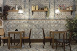 Restauracja z dwoma stolikami, czterema krzesłami, wiszącymi półkami na ścianie, kwiatami i płytkami z kolekcji FS Roots