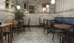 Restauracja ze stolikami, krzesłami, niebieską ławą, ozdobami na ścianach i płytkami z kolekcji FS Roots