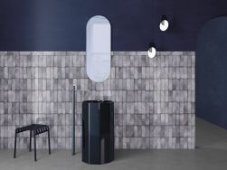 Minimalistyczna, ciemna łazienka z umywalką wolnostojącą, podłużnym lustrem, lampą wiszącą, lampą wiszącą, krzesełkiem i cegiełkami ściennymi z kolekcji Dyroy
