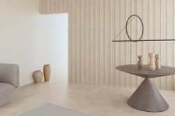 Minimalistyczne pomieszczenie z nowoczesnym stołem i lampą wiszącą, glinianymi dzbanami i płytkami Bow Clay