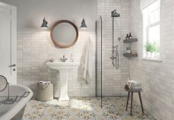 Łazienka z prysznicem, wanną, stojącą umywalką, okrągłym lustrem i płytkami z kolekcji FS Mud