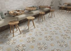 Restauracja z kanapami, okrągłymi stolikami przymocowanymi do ściany, stołkami i płytkami z kolekcji FS Clay