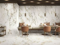 Elegancka restauracja z wiszącymi ławami z poduszkami, zastawionymi stolikami, brązowymi fotelami, lampami wiszącymi oraz płytkami podłogowymi i ściennymi imitującymi marmur z kolekcji Bellagio