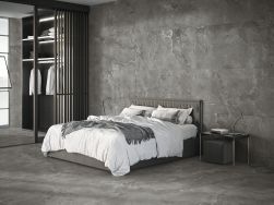 Sypialnia wyłożona antracytowymi płytkami imitującymi kamień Dome Anthracite z podwójnym łóżkiem, stolikiem nocnym i szafą