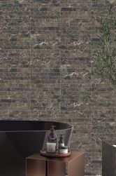 Ściana w łazience wyłożona brązowymi płytkami Capri Black oraz brązowa wanna wolnosojąca