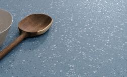 Zbliżenie na niebieską płytkę lastryko Evoque Blue z drewnianą łyżką i miską