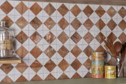 Ściana w kuchni wyłożona biało-brązowymi płytkami patchworkowymi FS Arles Brown LT z półką z naczyniami