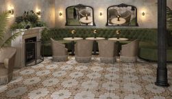Restauracja, przy ścianie zielona długa kanapa, okrągłe stoliki, kominek, podłoga wyłożona FS Paname Bastille 45x45 płytka patchworkowa