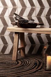 Ściana wyłożona dekoracyjnymi płytkami rustykalnymi FS Wabi Arrow, z drewnianym stołem i naczyniami