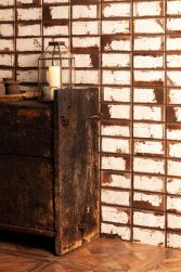 Ściana wyłożona biało-brązowymi cegiełkami rustykalnymi FS Iron White ze starą, drewnianą szafką z lampionem