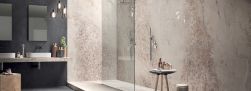 Łazienka wyłożona różowymi płytkami imitującymi kamień w połysku Gemstone Maxfine Rose Bright, z prysznicem, blatem z dwiema umywalkami nablatowymi i dwoma lustrami