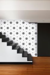 Korytarz ze ścianą wyłożoną biało-czarną mozaiką Mini Hexagon B&W Snow ze schodami
