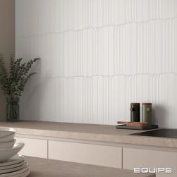 Ściana w kuchni wyłożona białymi płytkami Hopp White z meblami w kolorze kremowym
