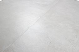 Zbliżenie powierzchni płytki imitującej beton w kolorze szarej bieli Terre Blanco 60x120