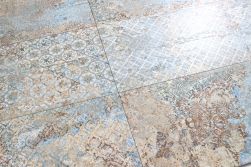 Zbliżenie na dekoracyjną powierzchnię płytek imitujących stary dywan Carpet Vestige Natural 50x100