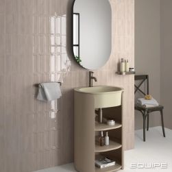 Łazienka ze ścianą wyłożoną beżowymi cegiełkami w połysku Island Frame Dorian, z beżową umywalką w szafce z półkami i owalnym lustrem