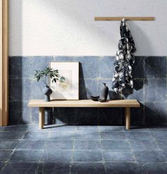 Korytarz, przy ścianie ławka, na ławce dekoracje, wieszak ścienny, połowa ściany w białym kolorze, pozostała część ściany i podłoga wyłożone Kintsugi Blue Aichi Natural 30,5x30,5