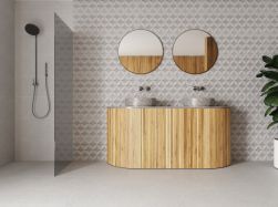 Łazienka wyłożona białymi płytkami lastryko imitującymi kamień Lakestone Cloud NT z kabiną prysznicową walk-in, drewnianą szafką stojącą z dwiema umywalkami nablatowymi oraz dwoma okrągłymi lustrami