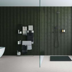 Łazienka z szarą podłogą i ciemnozieloną ścianą wyłożoną płytkami z kolekcji Lins, z kabiną prysznicową, białą wanną i półkami z ręcznikami oraz łazienkowymi akcesoriami