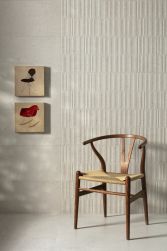 Ściana wyłożona beżowymi płytkami betonowymi lastryko Manhattan Bone z dwoma obrazkami i krzesłem