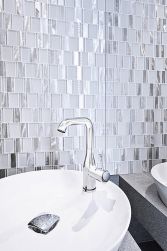 Ściana w łazience wyłożona białą mozaiką Allumi Piano White z umywalką nablatową z bateria