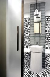 Łazienka wyłożona biało-czarną mozaiką Mini Hexagon B&W Coral z umywalką stojącą i lustrem