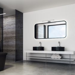 Nowoczesna łazienka z kabiną prysznicową, dwiema czarnymi umywalkami nablatowymi, długim lustrem i kinkietem Shine