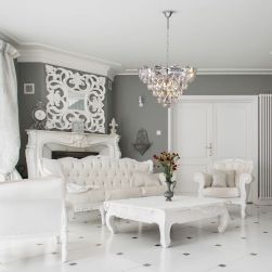 Elegancki salon z białymi meblami, kanapą, fotelami, stoliczkiem, wazonem z kwiatami i żyrandolem Sellena chrome 6xE14 glamour Milagro