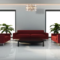 Salon z czerwoną kanapą, dwoma fotelami, czarnym stoliczkiem, kwiatami w donicach i eleganckim żyrandolem Austin chrome 6xE14 Milagro